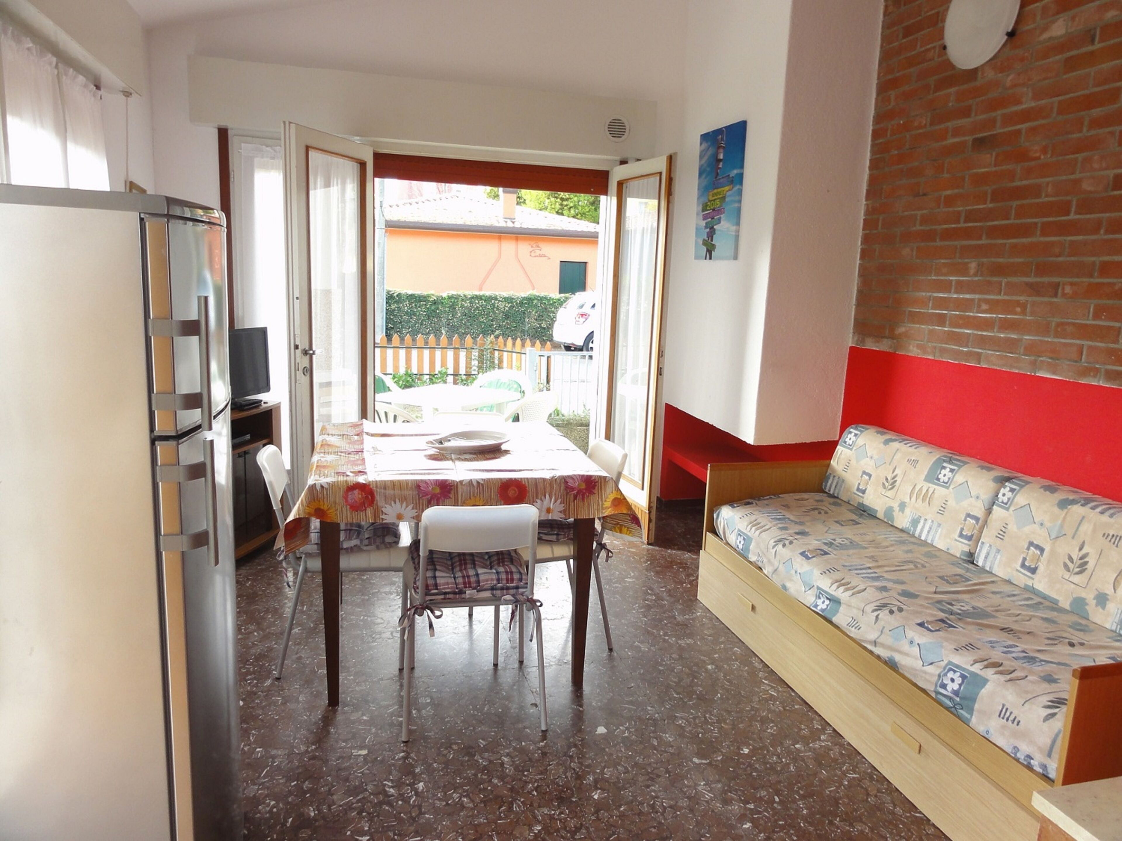 A compact living space with a dining area, a sofa, and a kitchen area.