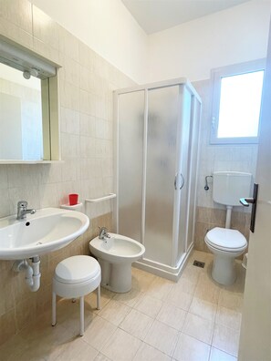 Ein Badezimmer mit Waschbecken, Bidet, Toilette und Dusche.