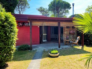 Un edificio rojo con un patio techado, una pared de ladrillo y un letrero con el número 7.