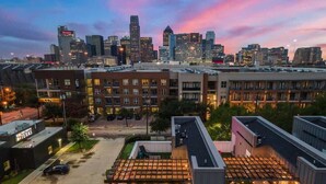 A rooftop patio area with outdoor seating and a view of the city skyline. - Designer Dallas Home, Rooftop, Kid Friendly Stay (Dallas)