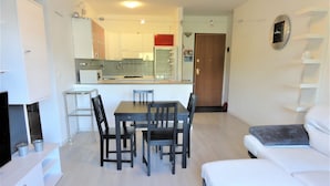 A modern apartment with a dining area, kitchen, and living room.