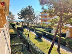 Una zona residencial con césped cuidado, setos y árboles.