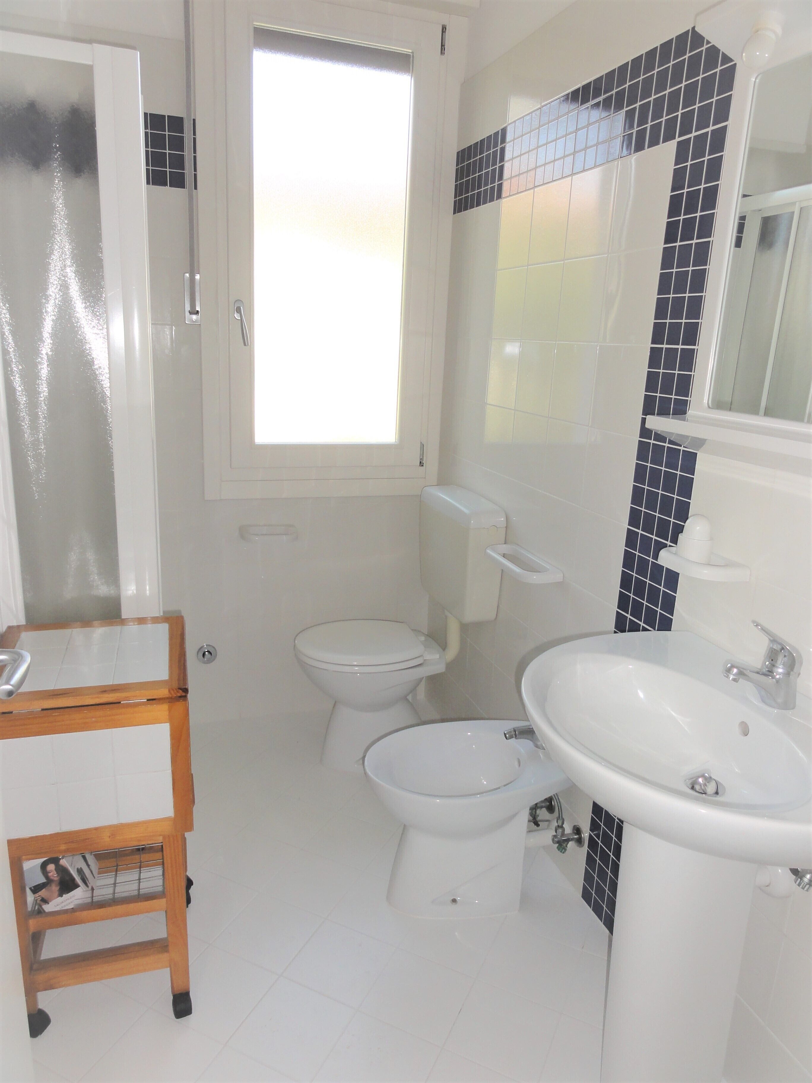 A bathroom with a toilet, bidet, and sink.