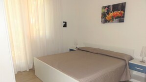 Une chambre à coucher avec un lit, une table de chevet, une lampe et un tableau au mur.