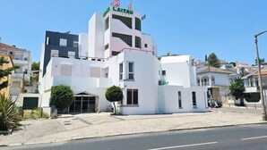 A modern hotel with a white facade, a rooftop terrace, and a sign indicating it is a hotel. - Hotel Laitau (Nossa Senhora da Anunciada)