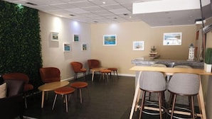 A modern interior with a green wall, multiple seating areas, and artwork on the walls. - Hotel Laitau (Nossa Senhora da Anunciada)