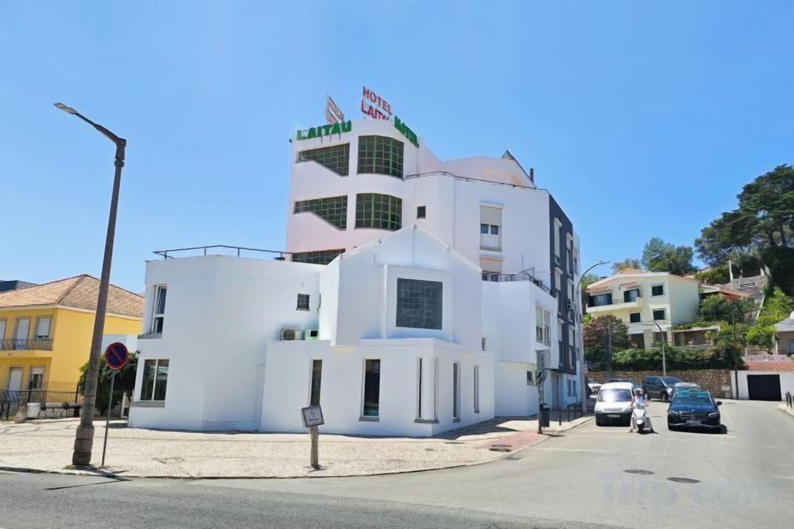 Un hotel bianco con una torre caratteristica e un cartello con su scritto 'HOTEL LAPA'.