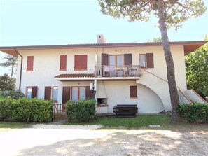 Un bâtiment à deux étages doté d’un balcon, d’une cheminée et d’un petit jardin.