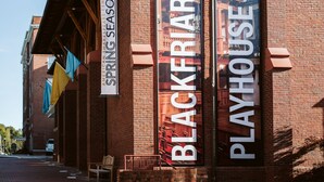 A brick building with signs for "American Shakespeare Center," "Blackfriars," and "Playhouse."