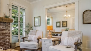 A cozy living room with two armchairs, a fireplace, and a mirror reflecting the room.