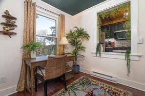 Un comedor con una mesa y una silla de madera, una lámpara y una alfombra estampada.