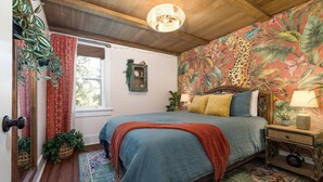 Quarto com cama, mesa de cabeceira, janela e porta.