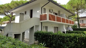Un bâtiment à deux étages doté d’un balcon, d’un escalier et d’un petit espace abrité.