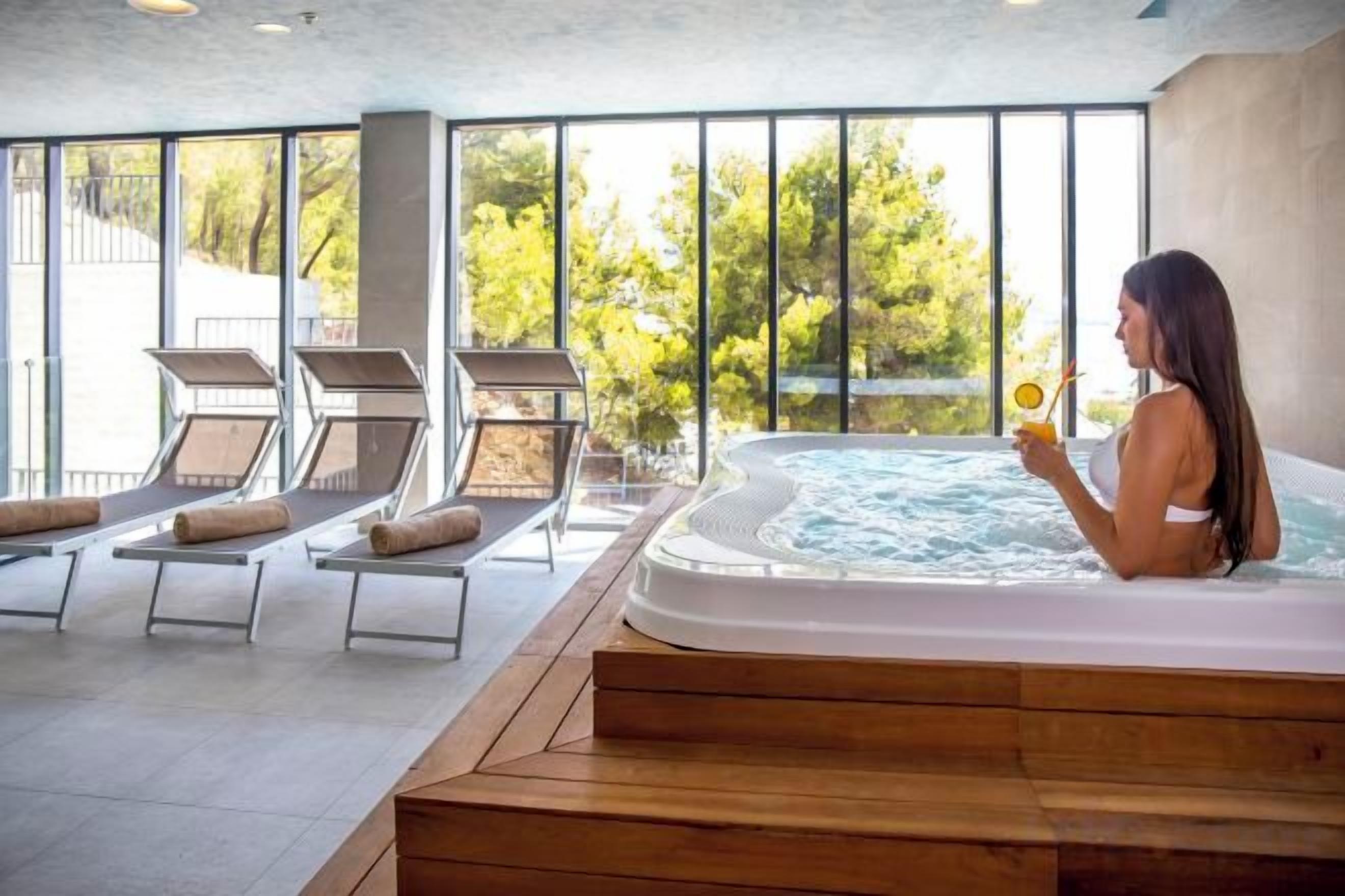 Un área de spa con jacuzzi y sillones reclinables.