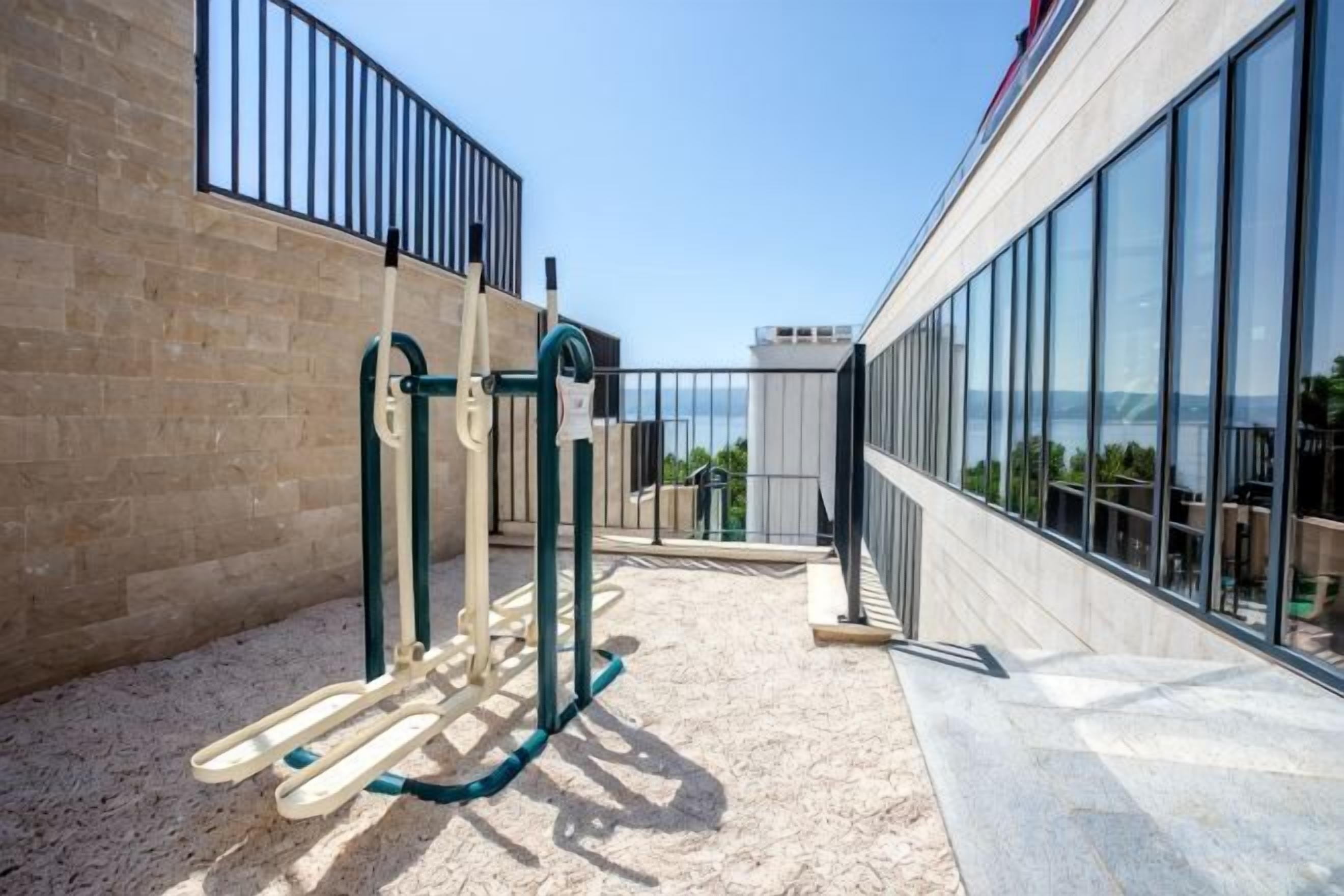 An outdoor exercise area with a climbing wall and a view of the sea.
