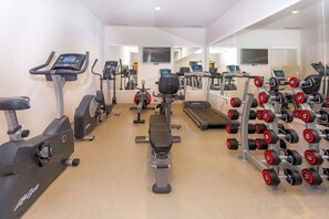 A gym with cardio machines, weight benches, and dumbbells. - Hotel Plaža Duće (Duce)