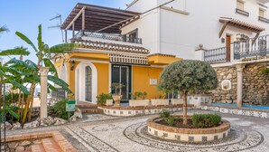 Un patio con suelo estampado, un pequeño árbol y un edificio con balcón.