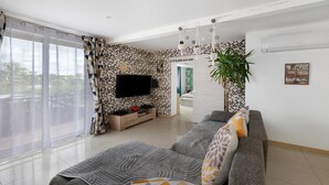 A modern living room with a sofa, TV, and a large window. - Gîte 'Gite Villarnoux' with Private Terrace, Wi-Fi and Air Conditioning (Bussières)