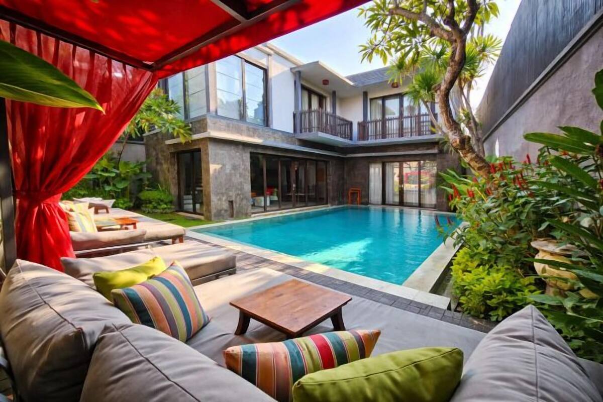 A modern pool area with a built-in seating area and a covered section.