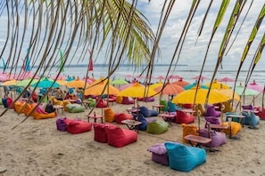 A beach with colorful umbrellas and bean bags. - Seminyak Icon Villa & Spa (Bali)