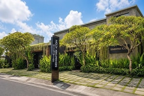 A modern building with a sign reading 'SEMINYAK ICON' and a well-maintained garden area. - Seminyak Icon Villa & Spa (Bali)