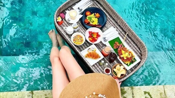 A dining table with food and drinks by a pool. - Seminyak Icon Villa & Spa (Bali)