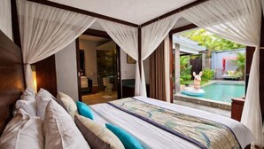 A bedroom with a large bed, a canopy, and a view of a swimming pool. - Seminyak Icon Villa & Spa (Bali)