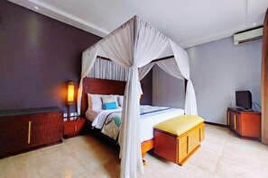 A bedroom with a four-poster bed, bedside tables, a nightstand, a television, and a wardrobe. - Seminyak Icon Villa & Spa (Bali)