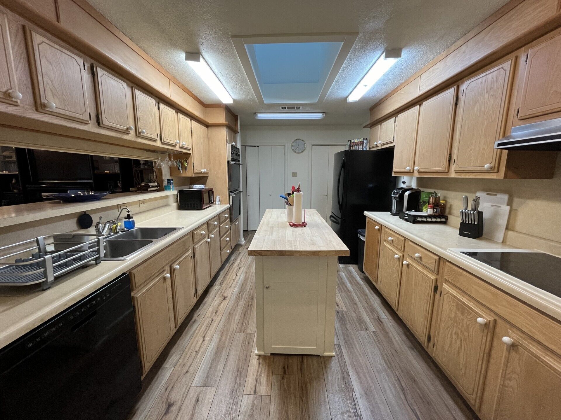 Une cuisine moderne avec des meubles en bois, un îlot central et des appareils électroménagers intégrés.