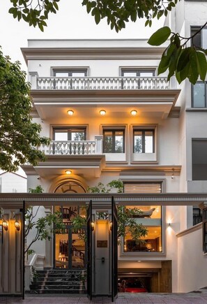 Un edificio a due piani con un balcone, una scala e un garage.
