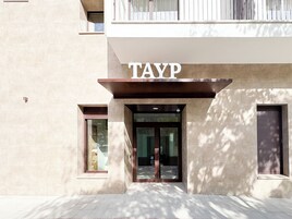 Una entrada de edificio con el letrero "TAYP" sobre la puerta.