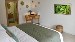 A bedroom with a bed, a desk, a chair, a small table, a lamp, and a picture on the wall. - Villa Kokoro - Monstera room (Saint-Paul)