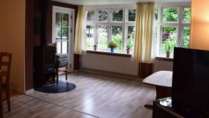 A room with a fireplace, a window with curtains, a radiator, and a table.