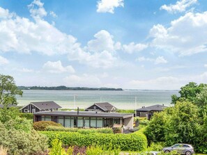 A coastal residential area with modern houses, a clear sky, and a view of the sea. - 5 Star Holiday Home in Sjolund (Sjølund)