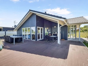 A modern house with a deck, large windows, and a covered patio area. - 5 Star Holiday Home in Skals (Skals)