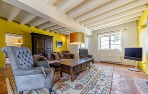 A living room with a sofa, armchairs, a coffee table, a TV, and a patterned rug. - Spacious Holiday Farm in the Loire Valley (Palluau-sur-Indre)