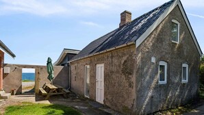 A stone cottage with a sloped roof, a wooden door, and a small window. - 5 Star Holiday Home in Grenaa (Grenaa)