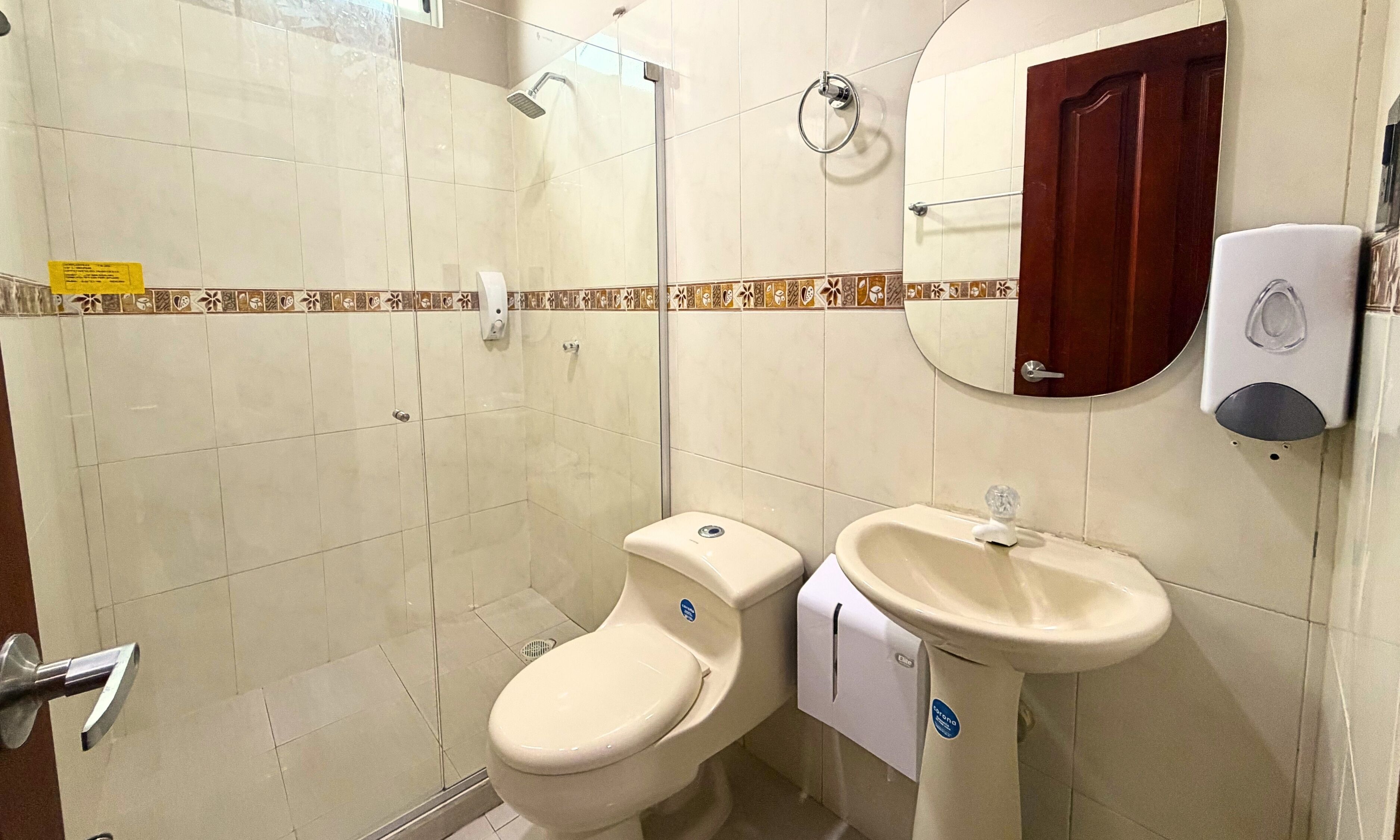 Baño con inodoro, bidé, ducha y secador de manos.