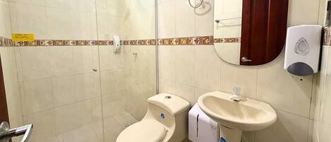 Baño con inodoro, bidé, ducha y secador de manos.