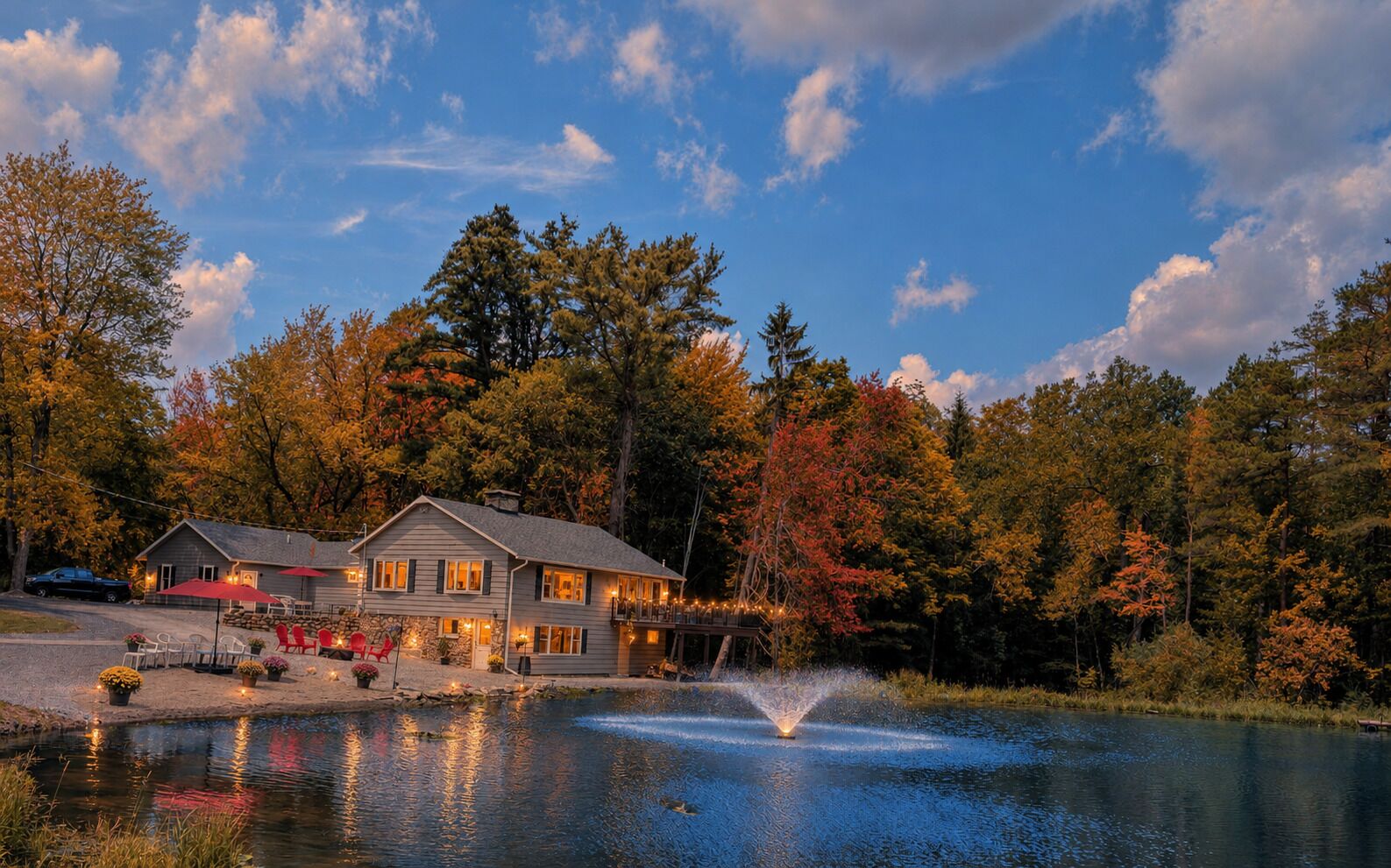 Une propriété au bord du lac, comprenant une maison, un espace extérieur aménagé et une fontaine.