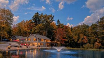 Une propriété au bord du lac, comprenant une maison, un espace extérieur aménagé et une fontaine.