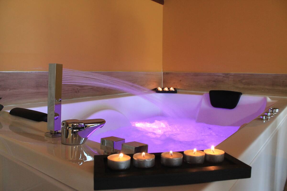 A bathtub with a water feature and candles.