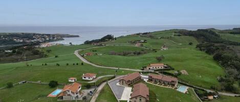 Zona residencial amb cases, una piscina i vistes al mar.