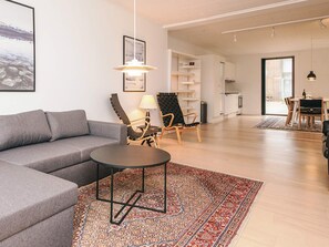 A modern living room with a grey sofa, a round coffee table, and patterned rugs. - 10 Person Holiday Park Home in Ulfborg (Ulfborg)