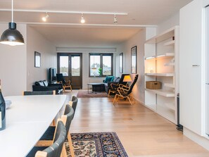 A modern living room with a dining area, large windows, and a view of the outdoors. - 10 Person Holiday Park Home in Ulfborg (Ulfborg)