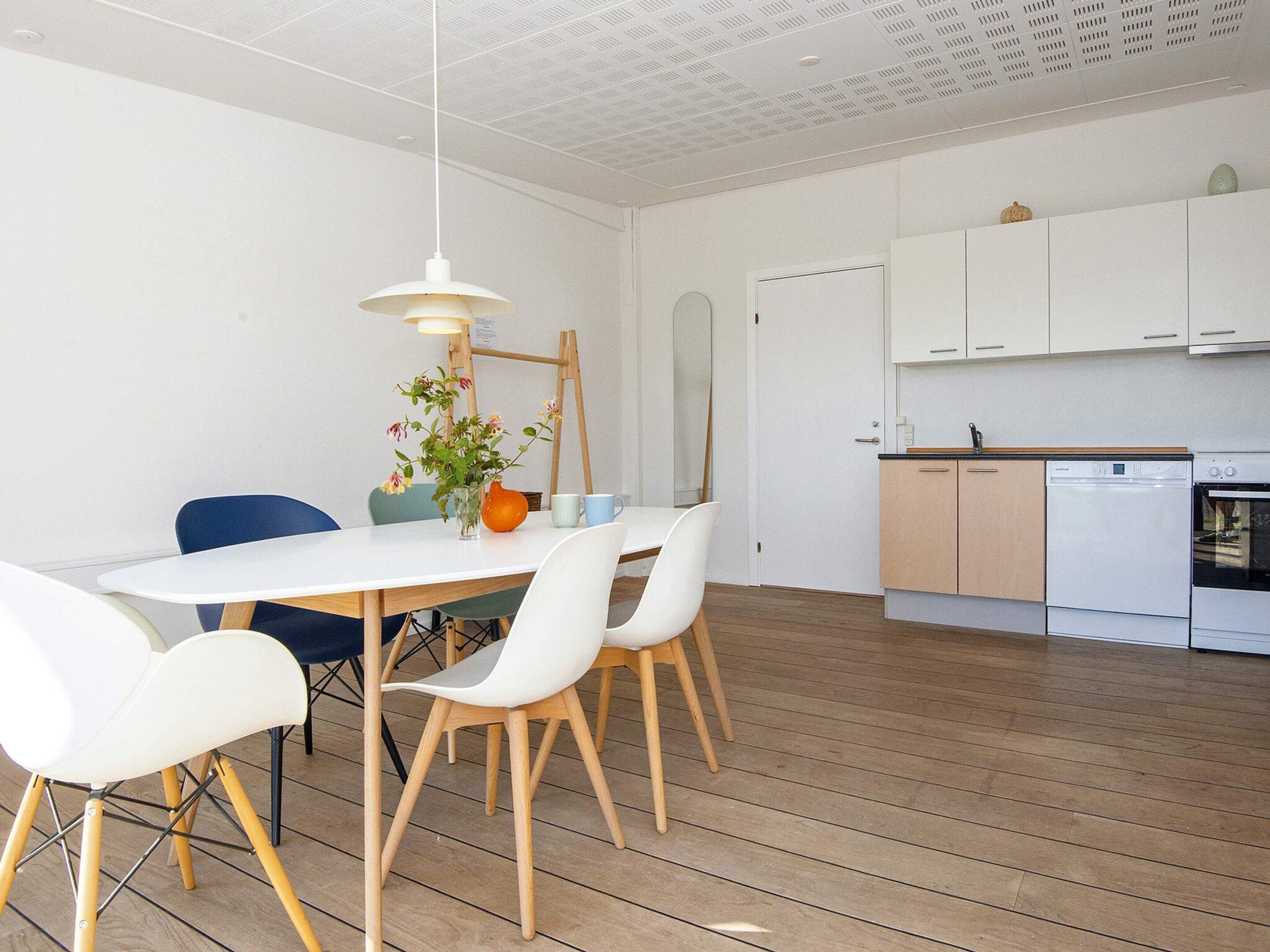 A modern kitchen with white cabinets, a dishwasher, and an oven.