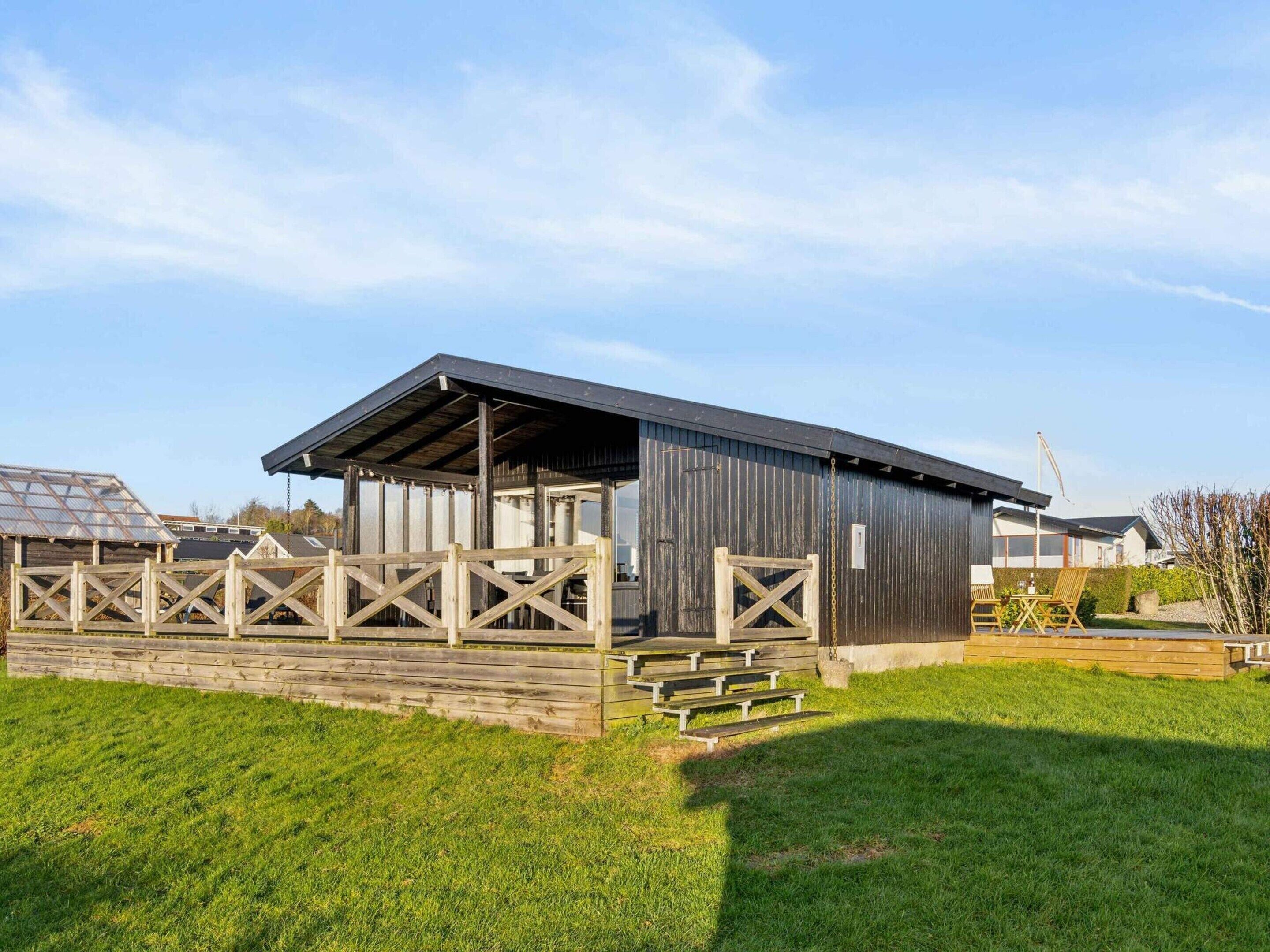 A rustic barn-style building with a covered porch and wooden benches.