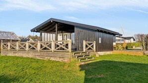 Ein rustikales Gebäude im Scheunenstil mit überdachter Veranda und Holzbanken.