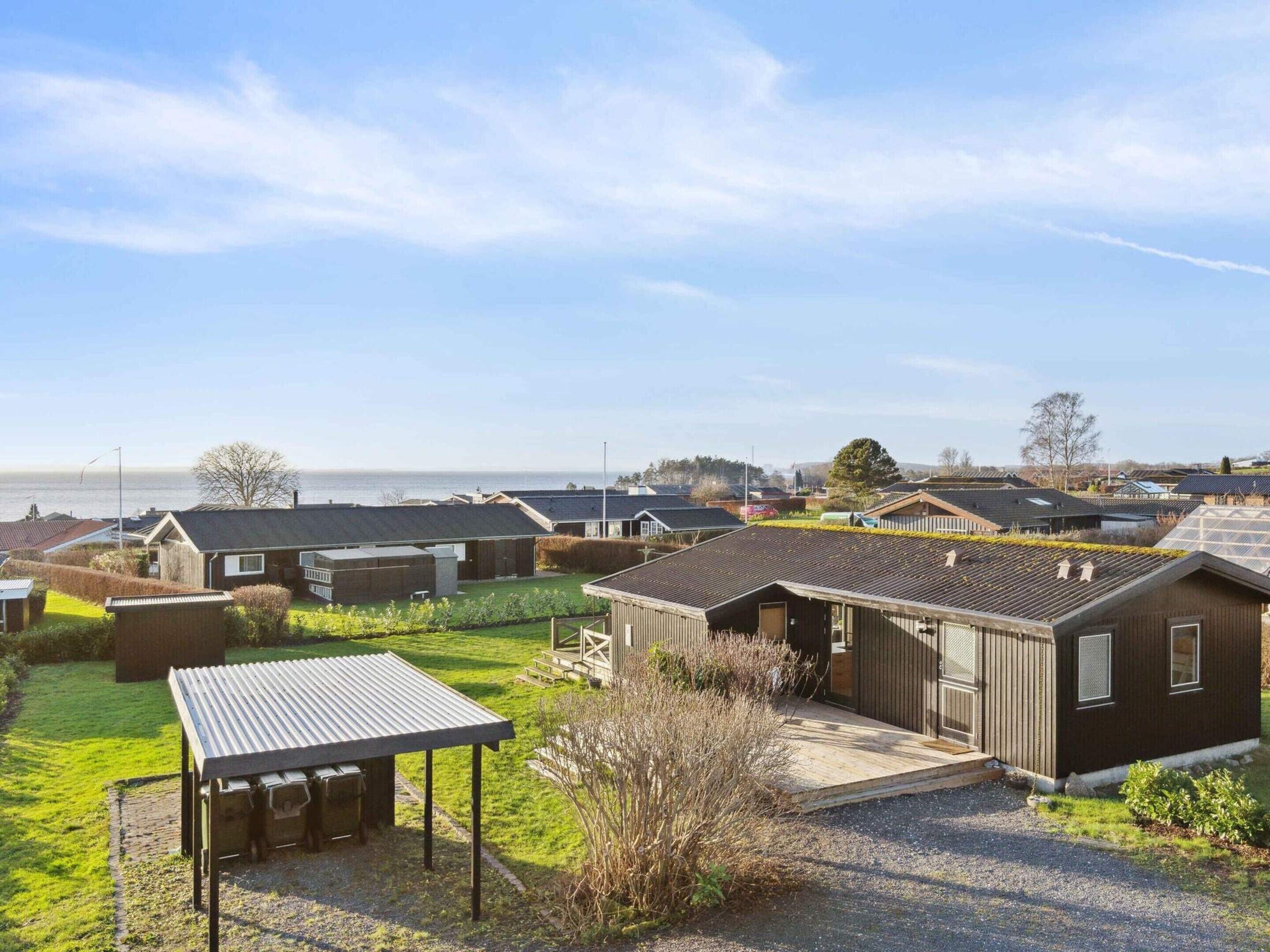 Un quartier résidentiel situé sur la côte, où les maisons se caractérisent par leurs toits inclinés et disposent d’un petit espace extérieur couvert aménagé en coin salon.