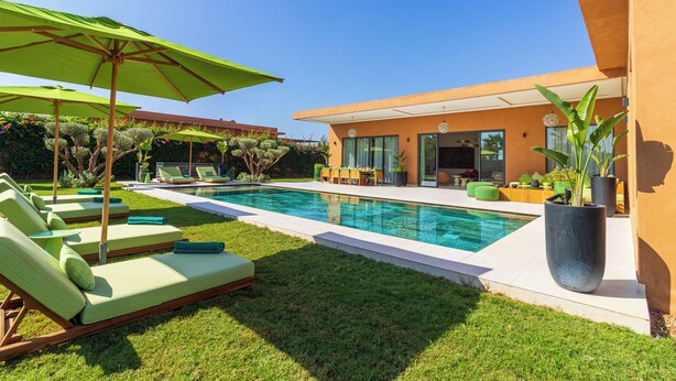 A modern house with a swimming pool, green lounge chairs, and umbrellas. - Villa Jamila Marrakech - Authentic luxury and heated private pool. (Marrakech)